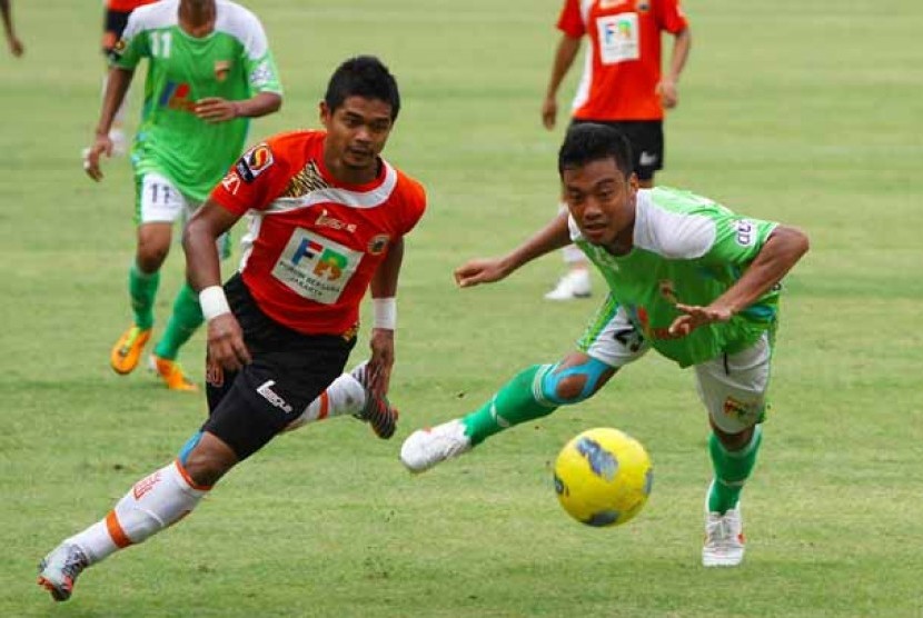 Penyerang Persija Jakarta, Bambang Pamungkas (oranye), berjibaku dengan pemain bertahan Mitra Kukar, Hamka Hamzah dalam laga lanjutan Liga Indonesia di Stadion Gelora Bung Karno, Senayan, Jakarta, Kamis (1/3). Pada pertandingan itu kedua tim berbagi hasil 