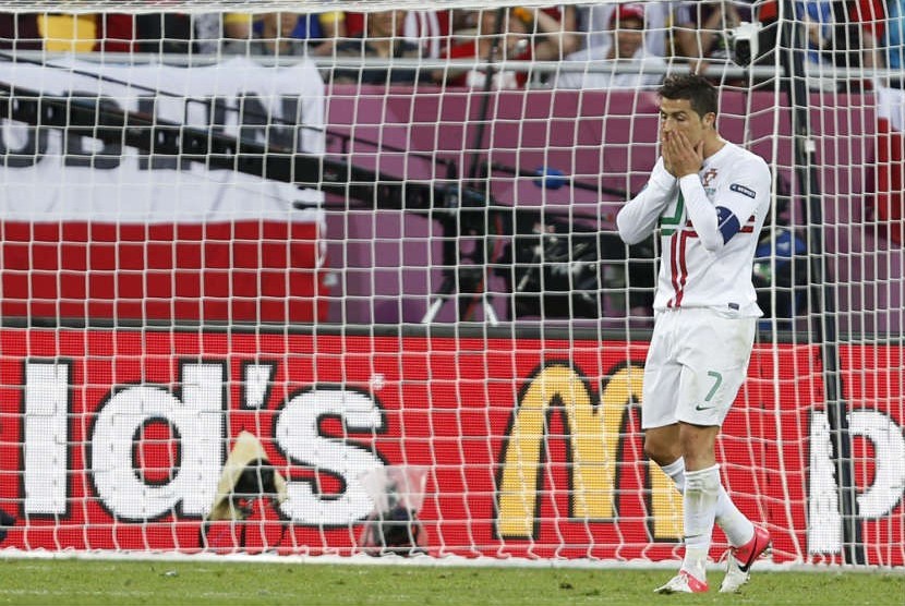   Penyerang Portugal, Cristiano Ronaldo mengusap wajahnya setelah gagal memanfaatkan peluang saat bermain melawan Denmark dalam pertandingan Grup B Piala Eropa 2012 di Stadion Arena Lviv, Ukraina, Rabu (13/6).