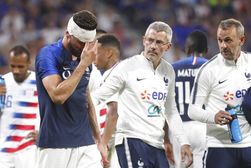 Penyerang Prancis Olivier Giroud (biru) keluar lapangan dalam pertandingan melawan Amerika Serikat setelah menderita luka di dahi.