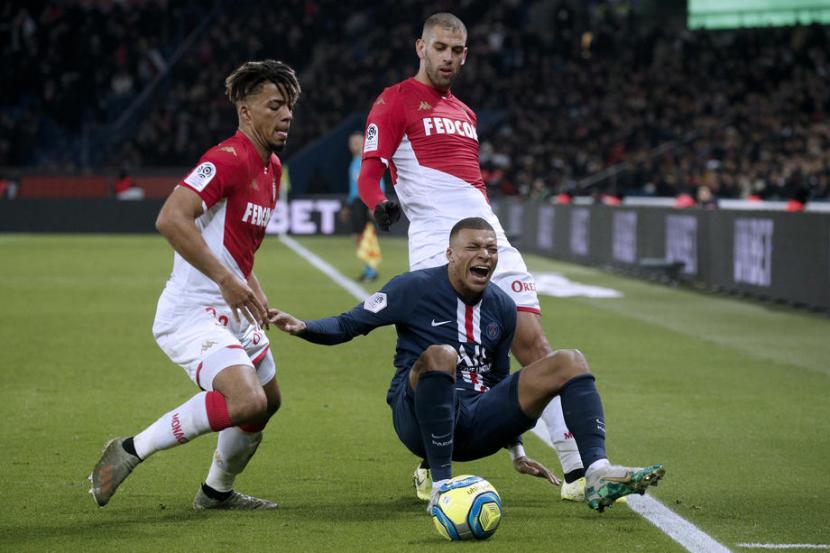 Penyerang PSG Kylian Mbappe (bawah) dijaga dua pemain AS Monaco. 