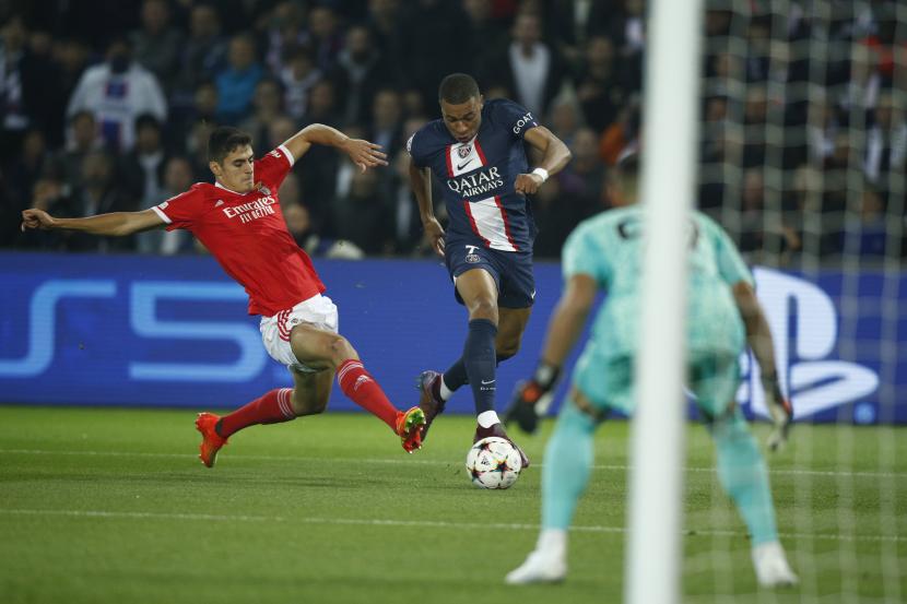 Penyerang PSG Kylian Mbappe (kanan) mencoba melewati pemain Benfica Antonio Silva (kiri) pada pertandingan fase Grup H Liga Champions di Paris, Rabu (12/10/2022).