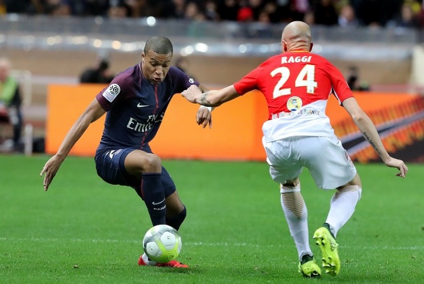 Penyerang PSG Kylian Mbappe (kiri) saat hendak melewati pemain AS Monaco.