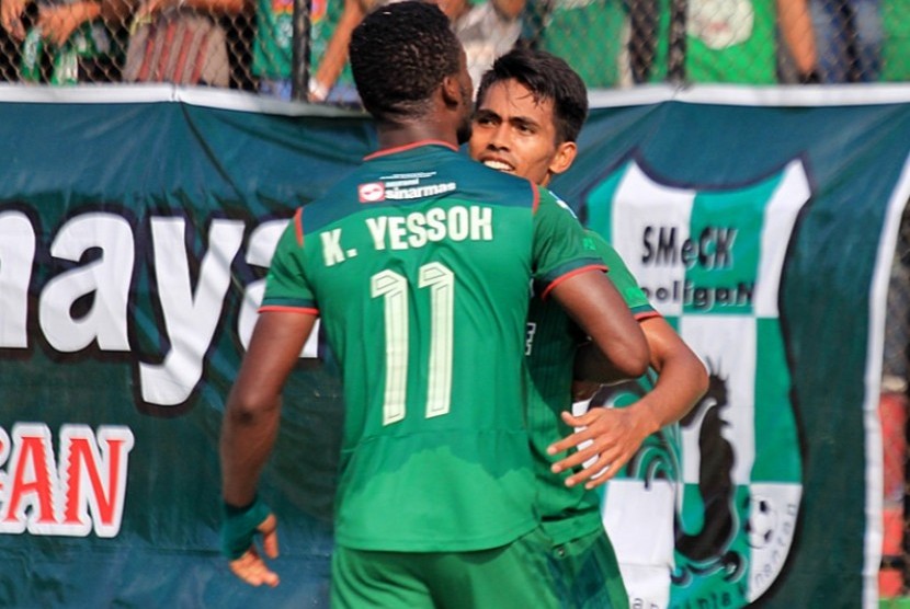 Penyerang PSMS, Wilfried Yessoh, merayakan gol bersama rekannya Frets Butuan.