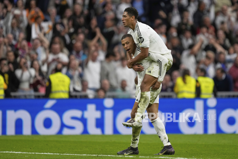 Penyerang Real Madrid Kylian Mbappe (bawah) merayakan golnya ke gawang Celta Vigo bersama Jude Bellingham dalam lanjutan La Liga Spanyol di Santiago Bernabeu, Ahad (4/5/2025) malam WIB. Mbappe mencetak dua gol untuk membawa Madrid menang 3-2.