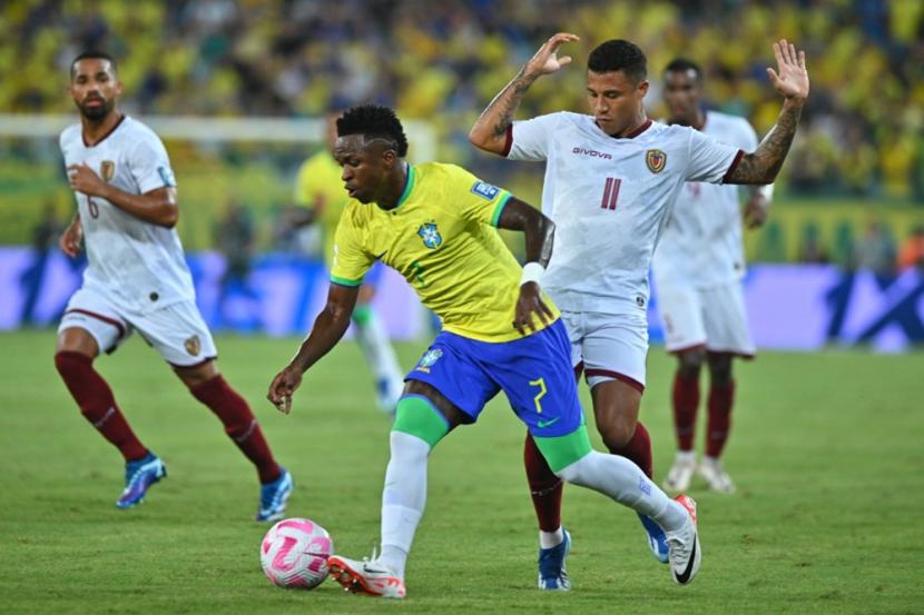 Penyerang sayap Brasil Vinicius Jr meliuk-liuk dijaga pemain Venezuela pada laga kualifikasi Piala Dunia 2026 zona Conmebol.