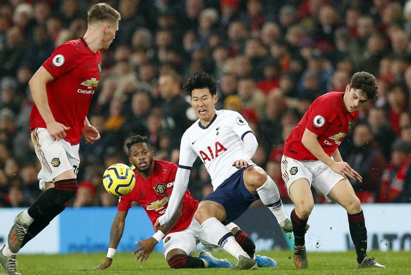 Penyerang Tottenham Hotspur Son Heung-min berjibaku menguasai bola melawan tiga pemain Manchester United (MU). MU mengalahkan Tottenham 2-1.