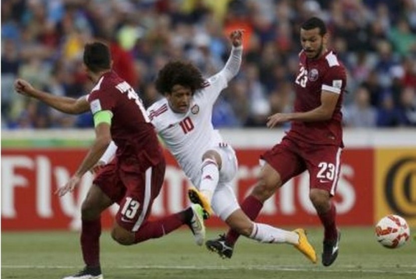  Penyerang UEA Omar Abdulrahman (tengah) diapit du pemain Qatar, Ibrahim Majed (kiri) dan Ahmed Mohamed Elsayed dalam pertandingan Grup C Piala Asia di Stadion Canberra, Ahad (11/1). UEA menang telak 4-1.