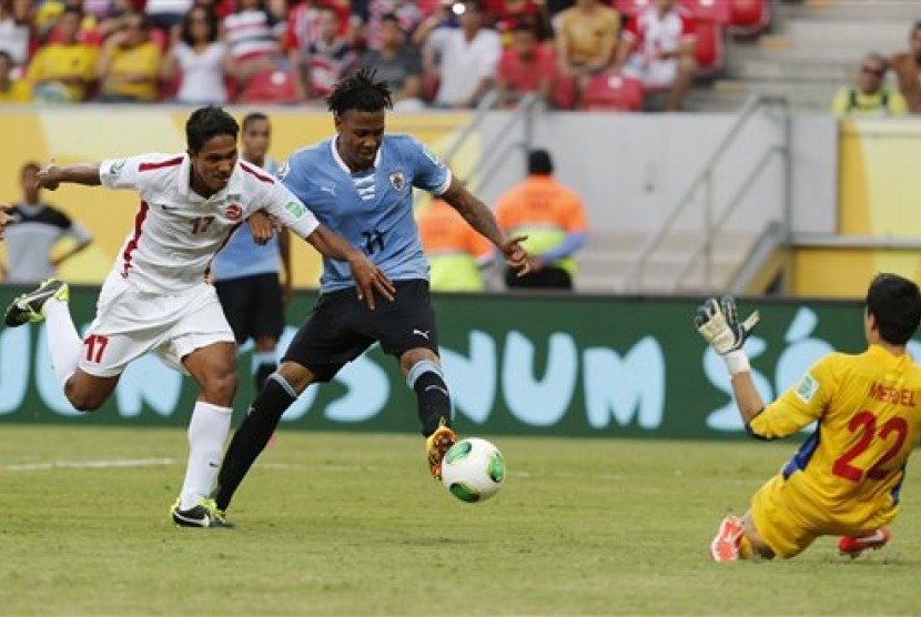 Penyerang Uruguay (kostum biru) mencetak gol ke gawang Tahiti di Piala Konfederasi 2013.