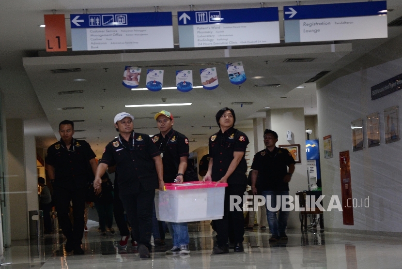 Penyidik Badan Reserse Kriminal Polri membawa berkas usai memeriksa Rumah Sakit Cipto Mangungkusomo (RSCM) Kencana, Jakarta, Kamis (4/2).  