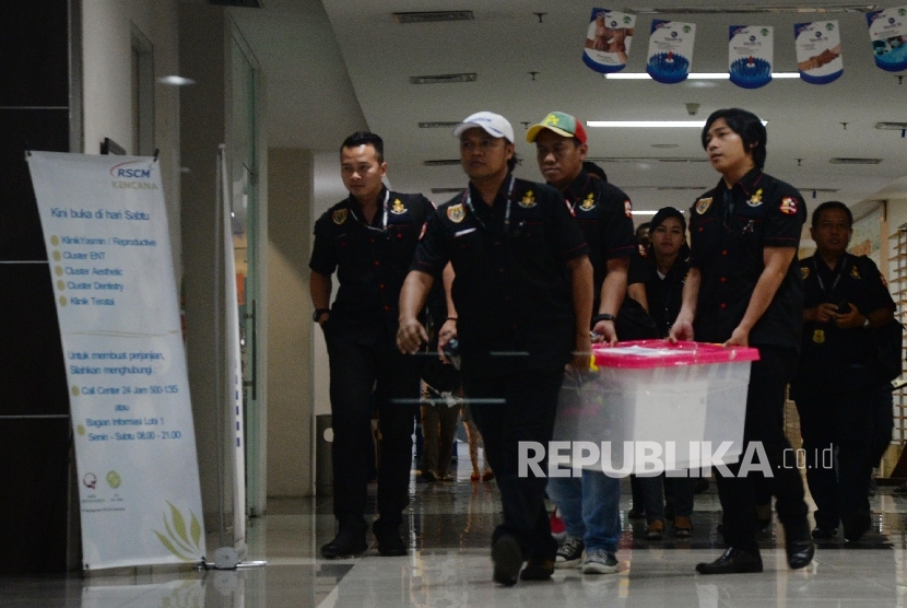 Penyidik Badan Reserse Kriminal Polri membawa berkas usai memeriksa Rumah Sakit Cipto Mangungkusomo (RSCM) Kencana, Jakarta, Kamis (4/2). 