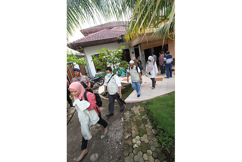 Penyidik KPK dikawal personel Brimob membawa koper usai melakukan penggeledahan di rumah kediaman Ketua DPRD Sumut Ajib Shah, di Jalan Sei Bengawan Medan, Sumatera Utara, Rabu (11/11).