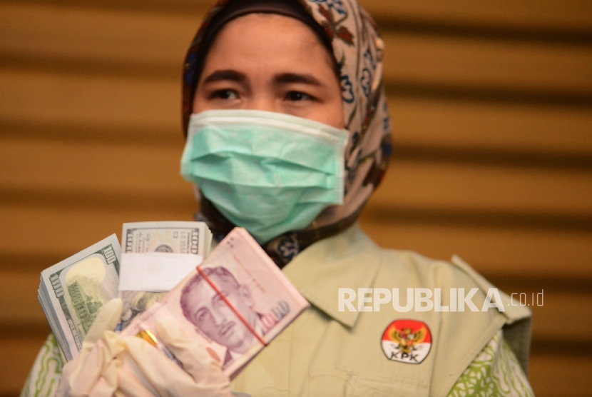  Penyidik KPK menunjukan barang bukti berupa uang dollar saat menggelar keterangan pers mengenai Operasi Tangkap Tangan (OTT) terhadap Deputi Bakamla, di Gedung KPK, Jakarta, Kamis (15/12).
