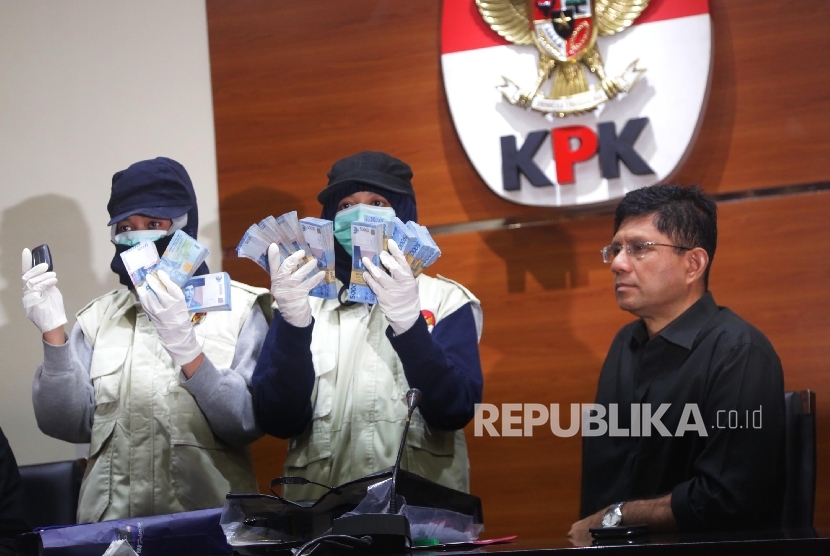 Penyidik KPK menunjukkan barang bukti terkait penangkapan Operasi Tangkap Tangan (OTT) Wali Kota Batu disaksikan Wakil Ketua KPK Laode M Syarif (kanan) saat konferensi pers di Gedung KPK, Jakarta, Ahad (17/9).