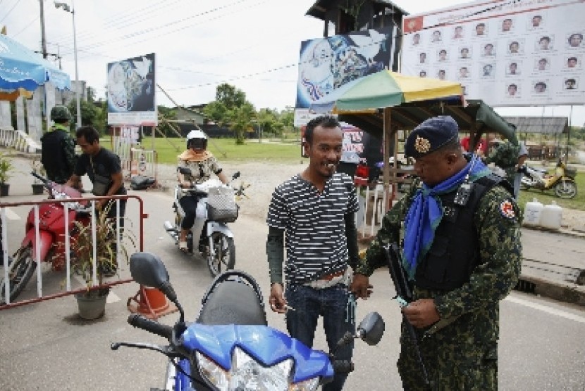 People are searched by soldiers at a checkpoint in the southern Narathiwat province