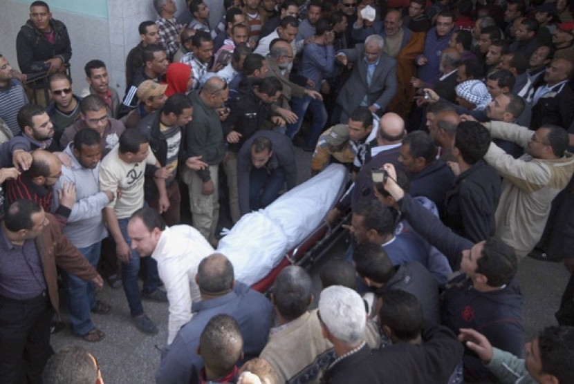 People carry body of a protester killed during clashes yesterday in the port city in Suez, about 134 km (83 miles) east of in Cairo January 26, 2013. At least 22 people died on Saturday when Egyptians rampaged in protest at the sentencing of 21 people to d