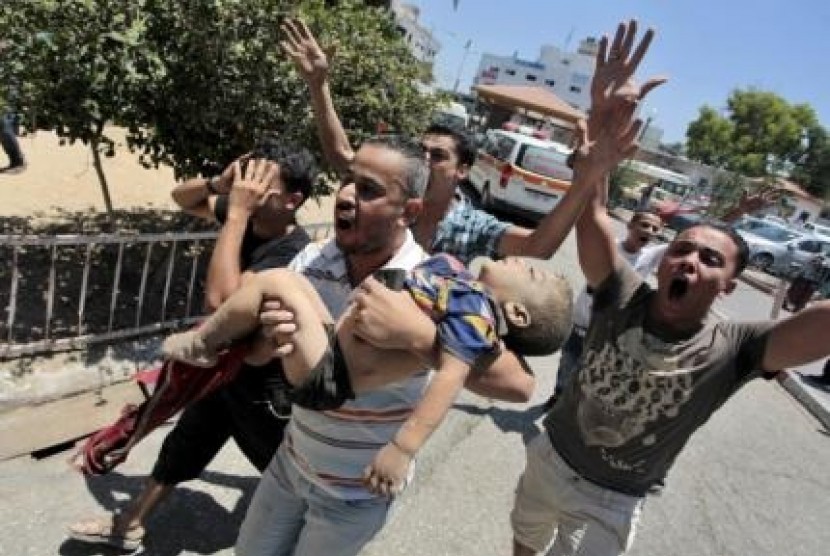 People carry the body of a Palestinian boy whom hospital officials said was killed in an Israeli air strike on his family's house, in Gaza city July 9, 2014. 