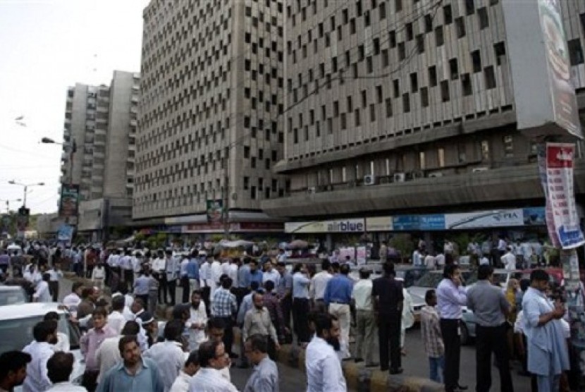 People evacuate buildings and gather on road after a tremor of an earthquake was felt in Karachi, Pakistan, Tuesday, April 16, 2013. A major earthquake described as the strongest to hit Iran in more than half a century flatted homes and offices Tuesday nea
