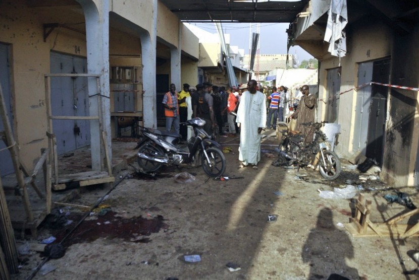 People gather at the scene of a double suicide bomb attack at the Kantin Kwari textile market in Kano December 10, 2014. Four people were killed and seven injured when two female suicide bombers attacked the Kantin Kwari textile market in Nigeria's second 