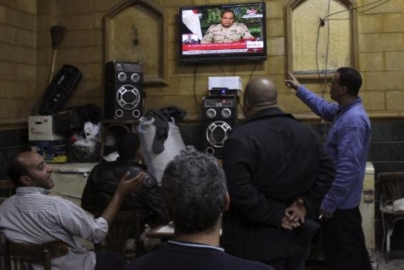 People listen to the speech by Egypt's army chief Field Marshal Abdel Fattah al-Sisi declaring his candidacy for a presidential election, in a public cafe in Cairo March 26, 2014. 