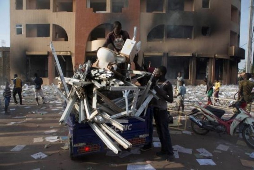 People load goods looted from a building, which according to locals, belongs to Francois Compaore, the younger brother of Burkina Faso's President Blaise Compaore, in Ouagadougou, capital of Burkina Faso, October 30, 2014.