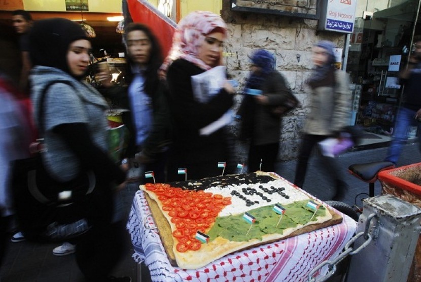 People look at a pizza displayed outside a restaurant, with toppings arranged to depict a Palestinian flag, in the West Bank city of Ramallah November 29, 2012. Italy will support a United Nations resolution on Thursday giving Palestine the status of a 