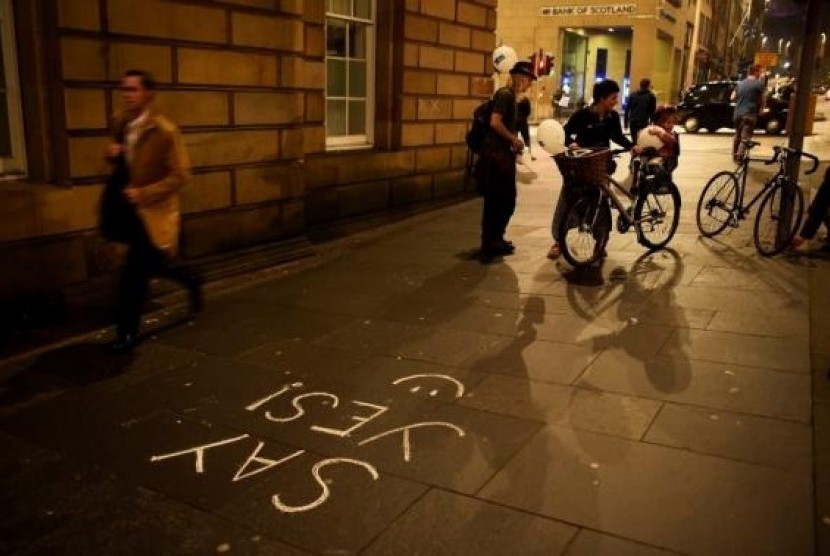 People pass some 'Yes' graffiti on the Royal Mile in Edinburgh, Scotland September 16, 2014.