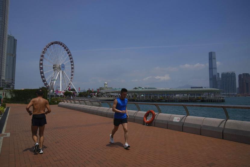 People run at a waterfront in Hong Kong, Thursday, May 5, 2022. 