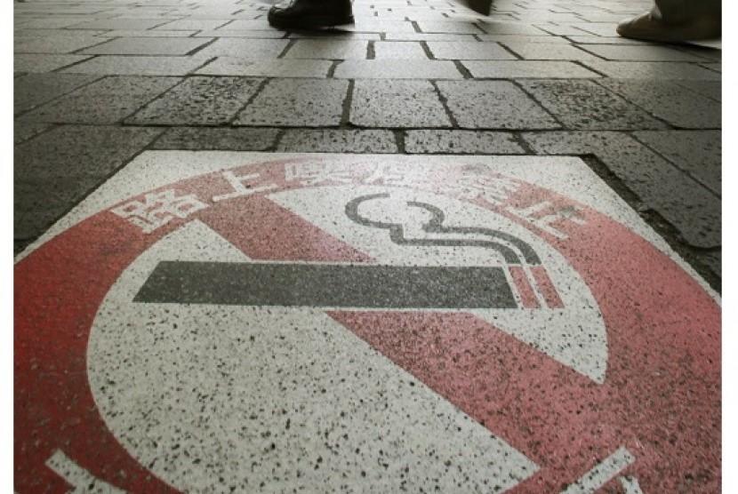 People walk near a no smoking sign on World No Tobacco Day, a day initiated by the World Health Organization which attempts to raise awareness on the dangers of smoking, in Tokyo, recently. In 2010, Japan imposed a record 40 percent tax hike on cigarettes 