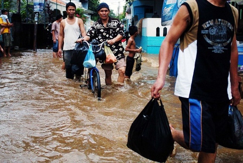 People walk through the flooded area in Jakarta. (illustration)  