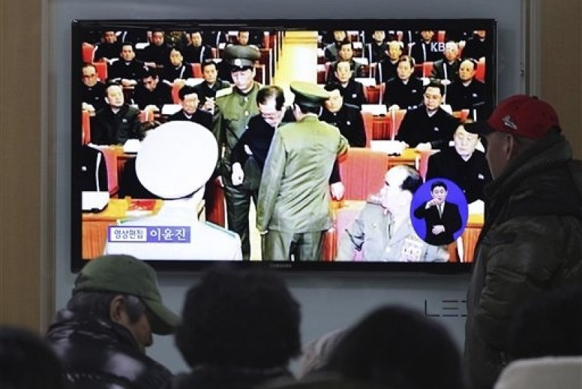 People watch a TV news program at Seoul Railway Station, South Korea, Monday, Dec. 9, 2013 showing Jang Song Thaek, center, uncle of North Korean leader Kim Jong Un, being grabbed during an emergency meeting of Workers Party's Central Committee in Pyongyan