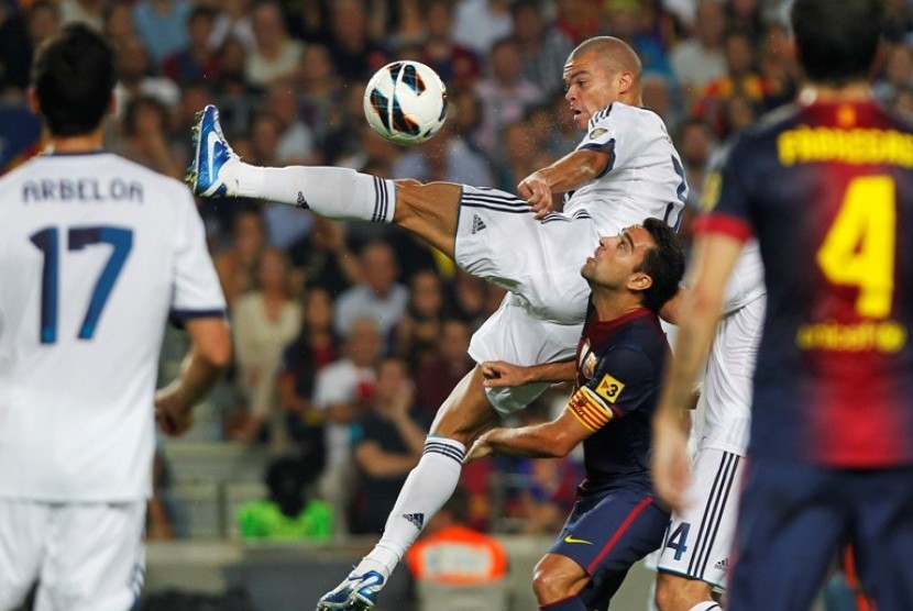 Pepe berebut bola dengan Xavi Hernandes dalam laga El Classico di Camp Nou (7/10) 