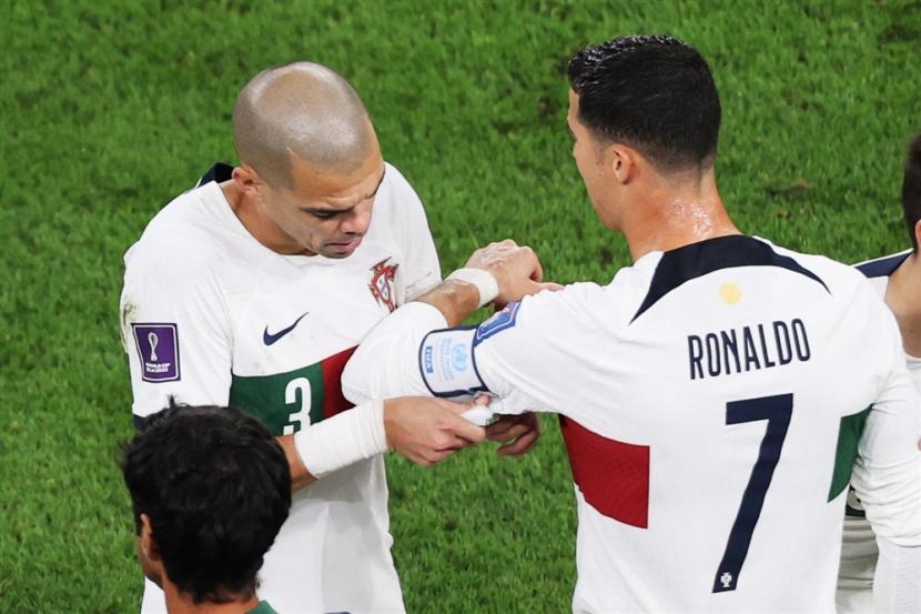  Pepe dari Portugal mengenakan ban kapten pada Cristiano Ronaldo saat ia memasuki lapangan selama pertandingan sepak bola perempat final Piala Dunia FIFA 2022 antara Maroko dan Portugal di Stadion Al Thumama di Doha, Qatar,  Sabtu (10/12).