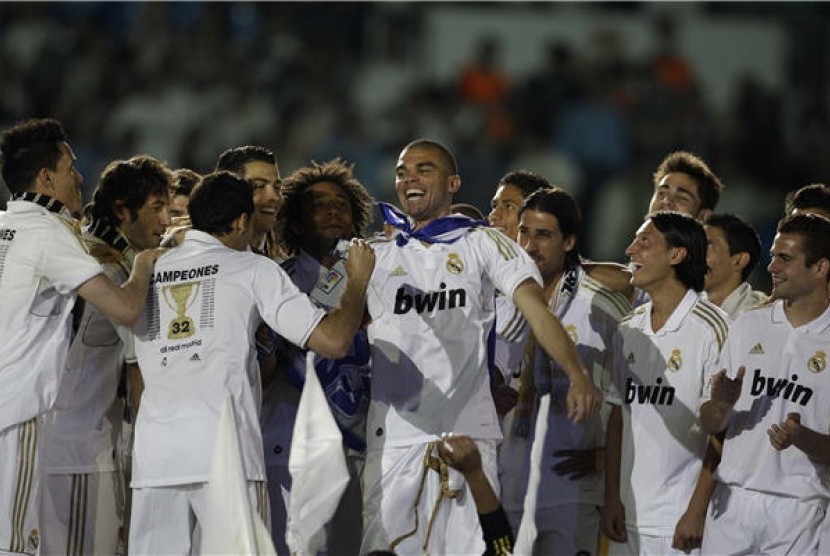 Pepe (tengah), pemain Real Madrid asal Portugal, berfoto bersama rekan setimnya saat merayakan kemenangan merebut gelar juara La Liga Spanyol usai menghadapi Real Mallorca di Stadion Santiago Bernabeu, Madrid, Ahad (13/5). 