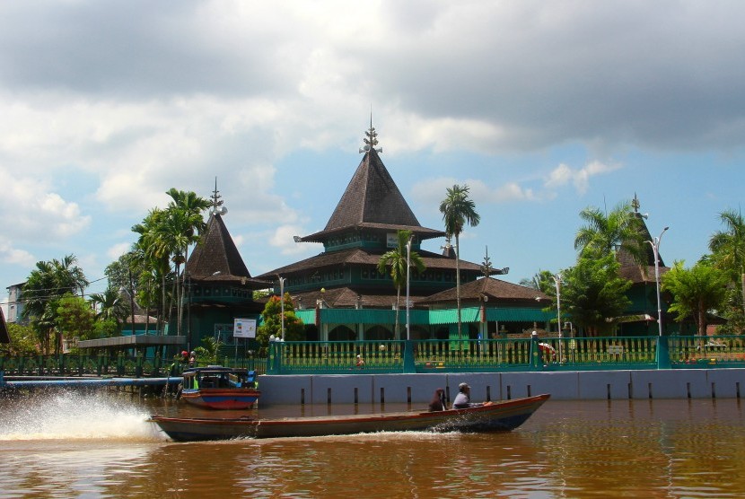 [Ilustrasi] Perahu bermesin (kelotok) melintas di sungai kuin berlatar Masjid Sultan Suriansyah Banjarmasin, Kalimantan Selatan.