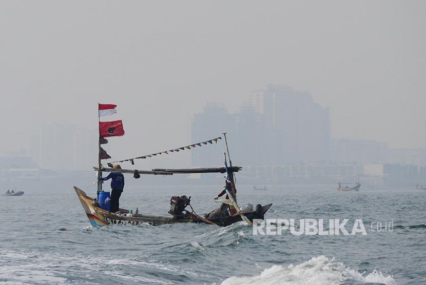 Perahu nelayan berlayar di perairan Teluk Jakarta.