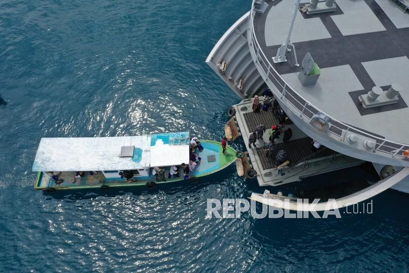 Perahu nelayan yang membawa warga Pulau Pramuka dan Pulau Panggang, Kabupaten Kepulauan Seribu, merapat ke haluan KRI Teluk Youtefa-522 yang lego jangkar saat Operasi Serbuan Vaksinasi Masyarakat Maritim di Perairan Kepulauan Seribu, Provinsi DKI Jakarta, Jumat (23/7/2021). 