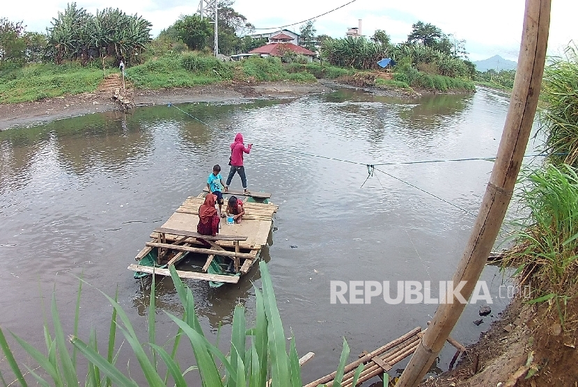 Perahu penyebrangan membawa warga menyebrangi Sungai Citarum, di Desa Andir, Kecamatan Baleendah, Kabupaten Bandung, Selasa (31/1).