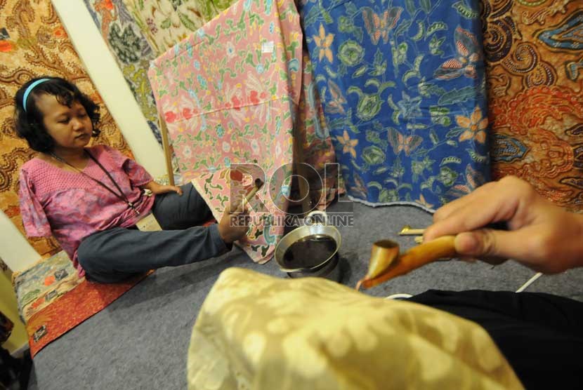  Perajin difabel asal Kota Solo, Ayu Tri Handayani (22) membatik kain dengan kakinya di pameran Gelar Batik Nusantara 2013, Jakarta, Rabu (17/7).   (Republika/Aditya Pradana Putra) 