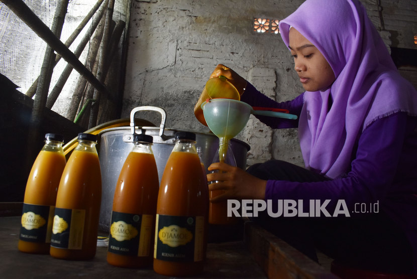 Perajin jamu menuangkan jamu cair berbahan rempah-rempah ke dalam botol di industri rumahan jamu tradisional di Kota Madiun, Jawa Timur, Kamis (5/3/2020).(Antara/Harviyan Perdana Putra )