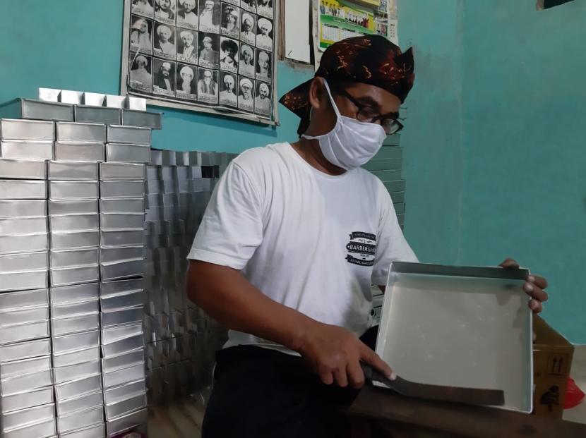 Perajin loyang, Nuryaman, menyelesaikan pembuatan produk loyang di sentra industri UMKM Binaan Yayasan Dharma Bhakti Astra (YDBA) di Bogor, Rabu (12/8). YDBA berkolaborasi dengan salah satu merchant di marketplace Indonesia, Toko Pasti Puas, memasarkan produk UMKM Binaan YDBA secara daring.