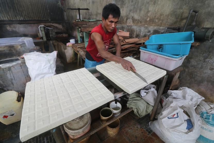 Perajin melakukan proses pemotongan saat pembuatan tahu takwa khas Kediri di sentra industri tahu, Kelurahan Tinalan, Kota Kediri, Jawa Timur, Senin (21/2/2022). Perajin terpaksa menaikkan harga jual tahu takwa dari sebelumnya Rp22.000 menjadi Rp23.000 per 10 potong akibat harga kedelai impor naik hingga Rp11 ribu per kilogram.