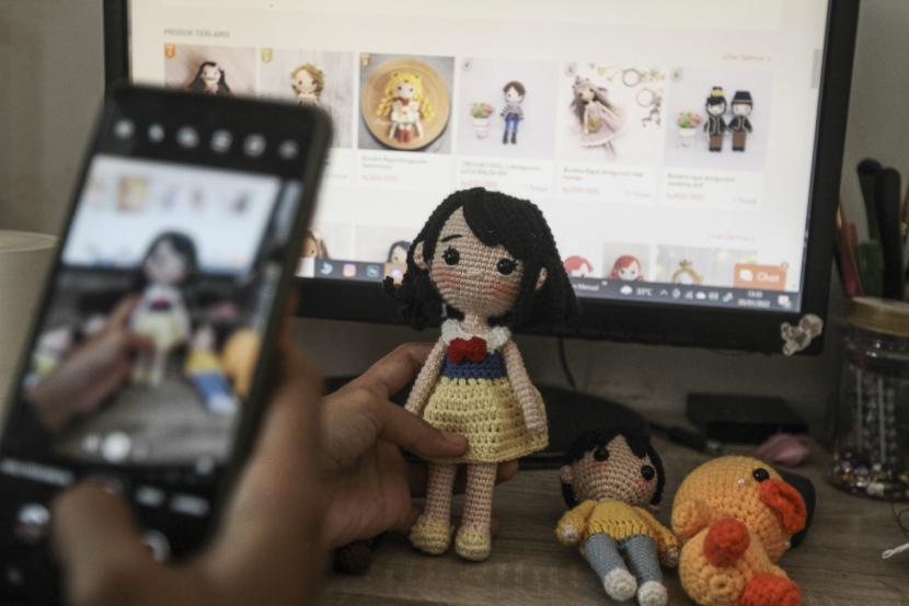 Perajin melihat stok produk kerajinan boneka rajut pada marketplace di Susan Craft, Depok, Jawa Barat, Rabu (5/1/2022). Pemerintah menargetkan, sebanyak 30 juta UMKM sudah go digital pada 2024.