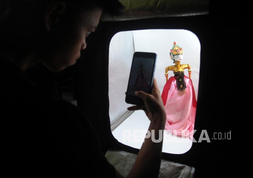 Perajin memotret produk wayang golek yang dipesan melalui pasar daring di UKM Golek Waris, Desa Tegal Waru, Ciampea, Kabupaten Bogor, Jawa Barat, Senin (27/12/2021). Menteri Koperasi dan UKM Teten Masduki mengatakan jumlah UMKM yang terhubung dengan ekosistem digital ditargetkan bertambah hingga mencapai 30 juta UMKM pada tahun 2024 mendatang.