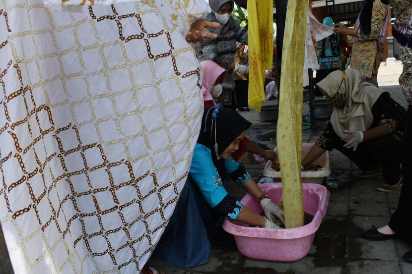 Perajin mengikuti kegiatan membatik bersama di Sendangrejo, Kabupaten Madiun, Jawa Timur, Sabtu (2/10/2021). Sejumlah perajin yang tergabung dalam Paguyuban Perajin Batik Kabupaten Madiun membatik bersama dalam rangka merayakan Hari Batik Nasional.