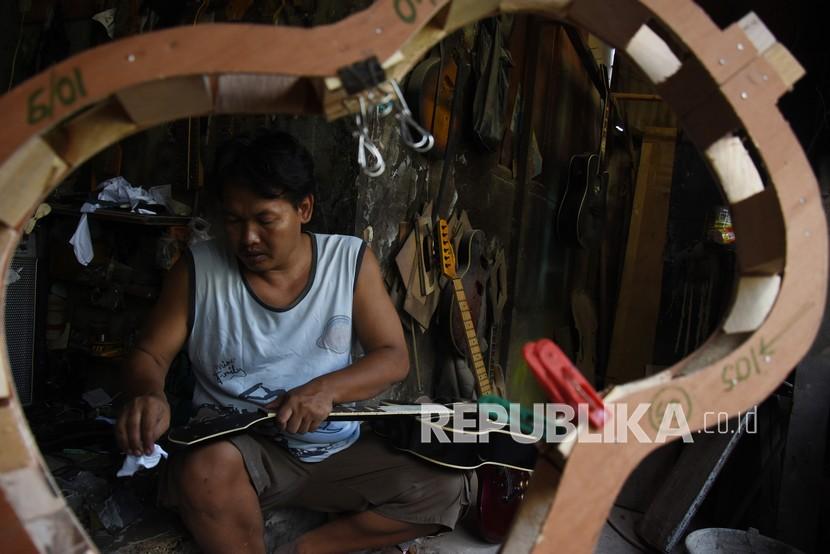 Perajin menyelesaikan pembuatan gitar di sentra produksi dan perbaikan gitar rumahan di kawasan Pasar Minggu, Jakarta, Jumat (21/8). PT Jamkrindo mencatat penjaminan Kredit Modal Kerja (KMK) UMKM dalam rangka Pemulihan Ekonomi Nasional (PEN) sebesar Rp 849,79 miliar hingga 24 Agustus 2020. 