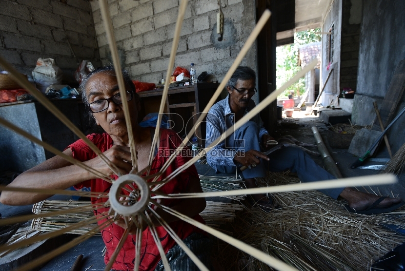   Perajin menyelesaikan proses pembuatan payung adat di Sentra Ukiran UMKM yang dibina oleh PT. ASABRI di Klungkung, Bali,  (Republika/Raisan Al Farisi)