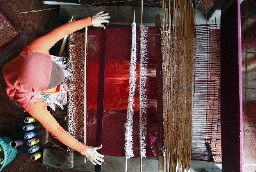 Perajin sedang menenun kain songket.