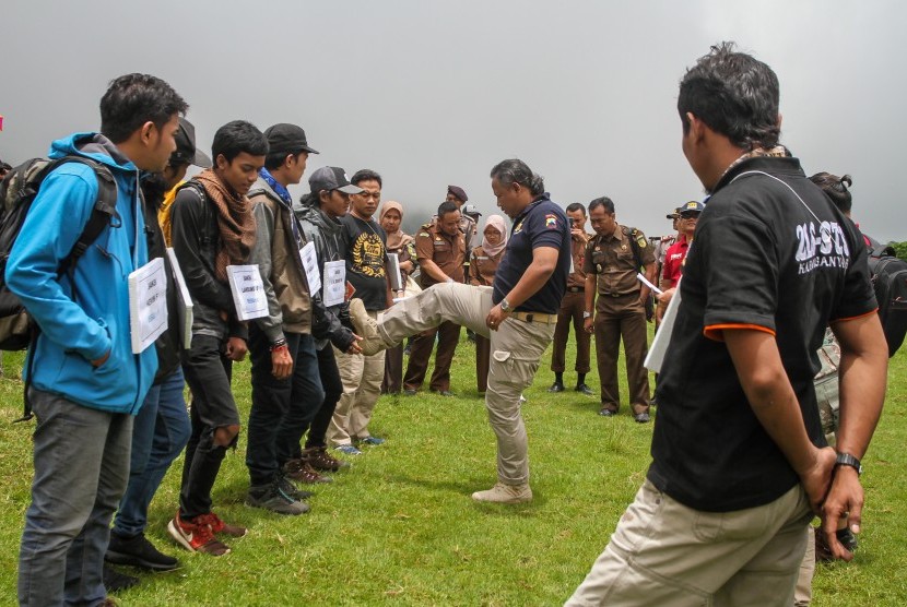 Peran pengganti tersangka memperagakan adegan kekerasan terhadap peserta pada rekonstruksi Diksar Mapala UNISI Universitas Islam Indonesia (UII) di desa Tlogodringo, Tawangmangu, Karanganyar, Jawa Tengah, Senin (13/3). 