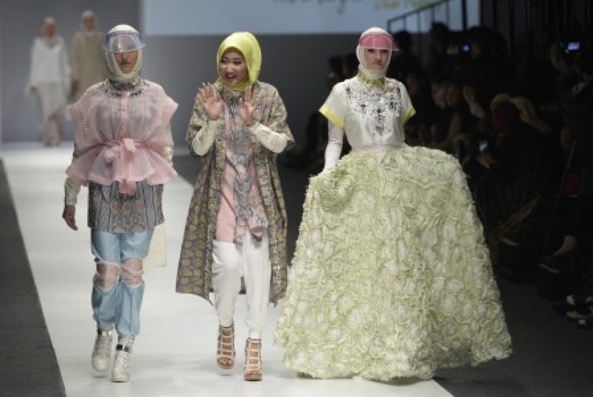 Perancang busana Dian Pelangi (tengah) bersama dua model yang mengenakan busana karyanya tampil dalam pembukaan Jakarta Fashion Week (JFW) 2016 di Jakarta, Sabtu (24/10). 