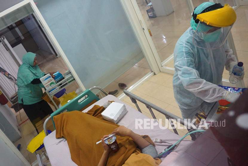Perawat dengan mengenakan pakaian APD (Alat Pelindung Diri) berupa baju Hazmat (Hazardous Material) melayani pasien suspect corona .